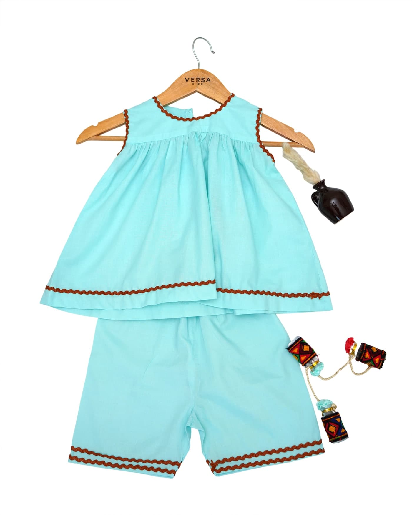 A turquoise top and shorts on a Versa Kids hanger