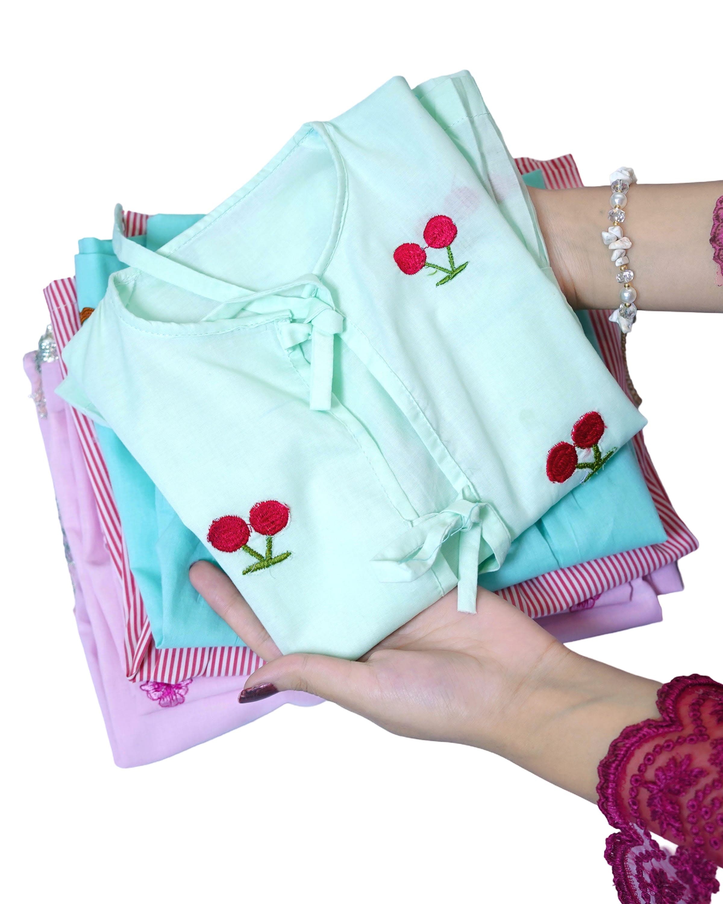 Hands holding a folded stack of children's clothes